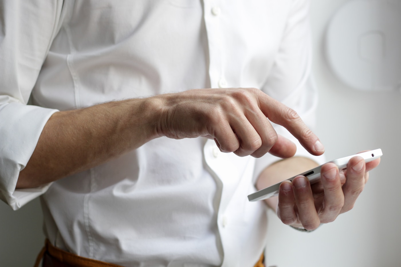 Pessoa revisando aplicativos e notificações em um celular ao lado de um checklist semanal em papel